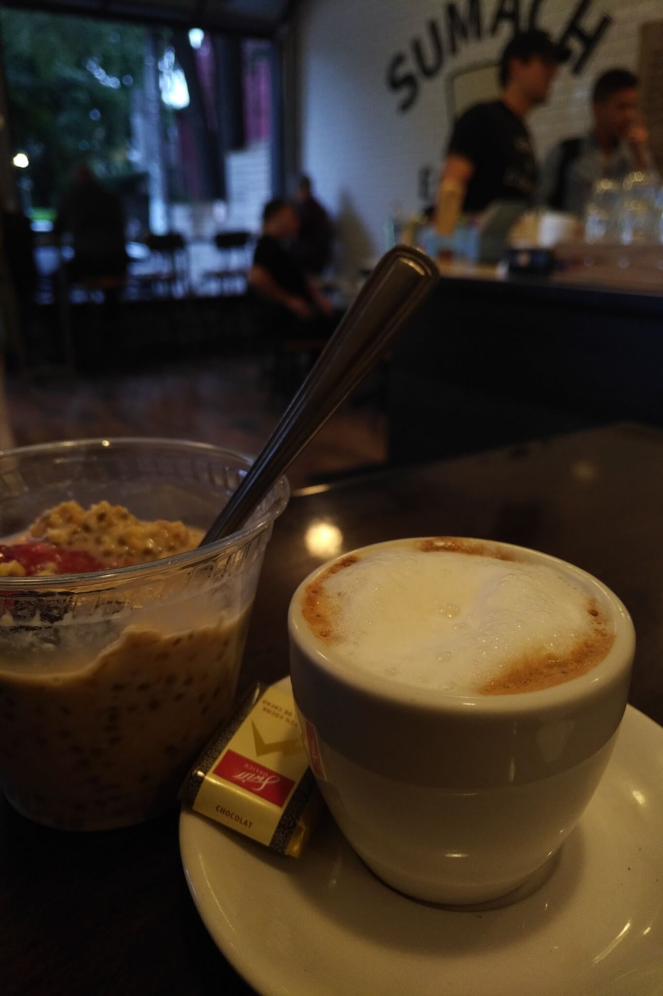 macchiato in single espresso cup with a plastic container of steel cut oatmeal adjacent