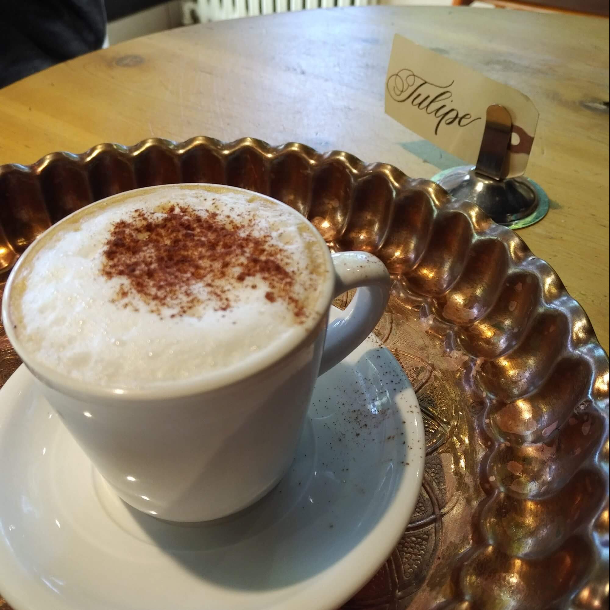 macchiato dusted with cinnamon and sitting on a copper tray