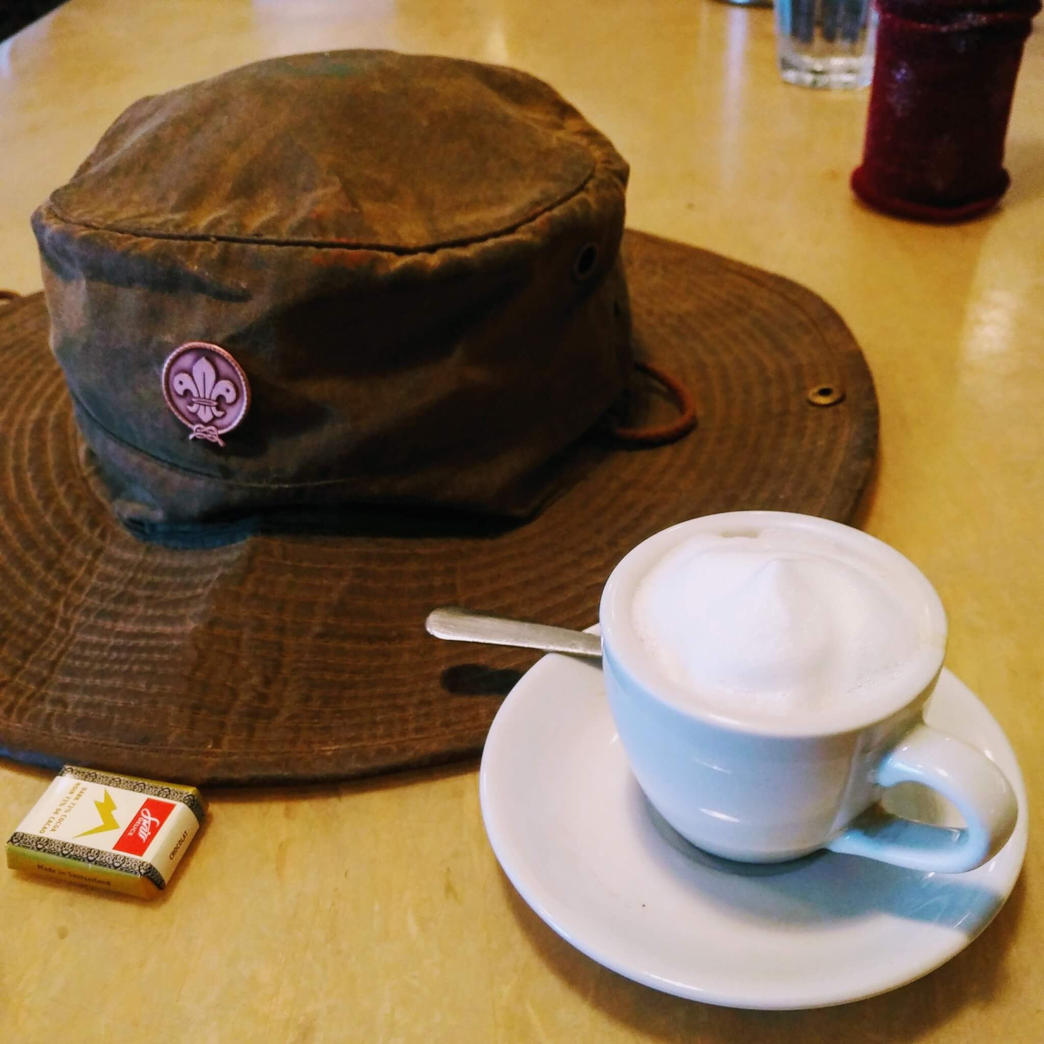 brown, wide-brimmed hat and a coffee